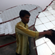 Workers clean solar concentrator panels at Kapodra village